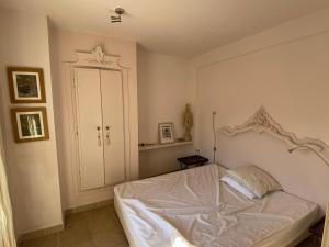 a bedroom with a white bed and a cabinet at Maison Marmont in Vela Luka