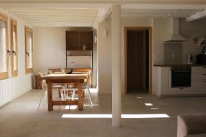 Una cocina y un comedor con mesa y sillas. en Appartement avec vue et jardin, en Formiguères