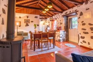 a kitchen and dining room with a wood stove at Aldeia da Cuada in Faja Grande