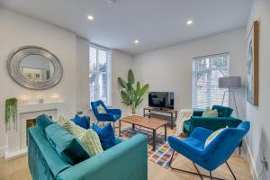 a living room with blue furniture and a mirror at Eden Grove 2 Bed Holiday Retreat With Hot Tub in Kirkby Thore