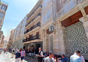 a group of people sitting outside of a building at Apartamentos Turísticos Puerto Cartago by CartagenaSpain in Cartagena
