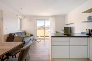 a kitchen and living room with a couch and a table at Apartment Mendelbahn in Caldaro