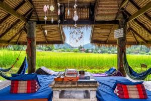 a tent with two hammocks and a rice field at Buzzas @ Pai Chan in Pai +49 photos