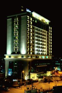 a hotel building with a lit up hotel at night at Radisson Hyderabad Hitec City in Hyderabad
