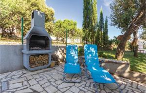 zwei blaue Stühle stehen neben einem Pizzaofen in der Unterkunft Two-Bedroom Apartment In Betiga in Barbariga + 20 Fotos