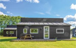 a black tiny house with a pitched roof at Holiday Home Halvejen Hytte Spjald Ii in Spjald