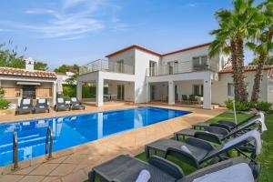 a villa with a swimming pool and chairs at Villa Angels in Teulada
