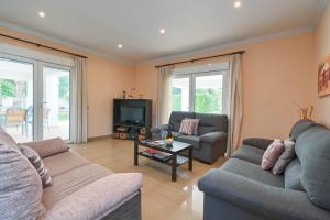 a living room with two couches and a tv at Villa Angels in Teulada