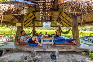 a group of people laying in hammocks under a hut at Buzzas @ Pai Chan in Pai
