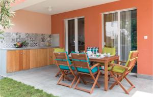 taras ze stołem i krzesłami z drewna w obiekcie Two-Bedroom Holiday Home In Barbariga w mieście Barbariga