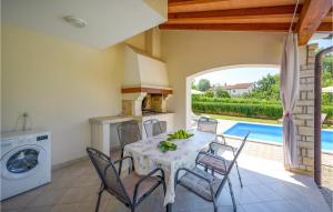 jadalnia ze stołem i krzesłami oraz basenem w obiekcie Three-Bedroom Holiday Home In Kmacici w mieście Kučići