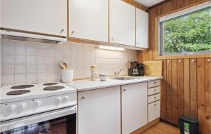 a kitchen with a white stove and a sink at Holiday Home Rønnemose Sydals Denm in Skovby +10 photos