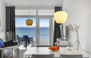 a living room with a table and a view of the ocean at Awesome Apartment In Ebeltoft in Ebeltoft