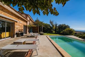 einen Pool mit Tischen und Stühlen neben einem Haus in der Unterkunft Maison Aux Vents in Monacia-dʼAullène