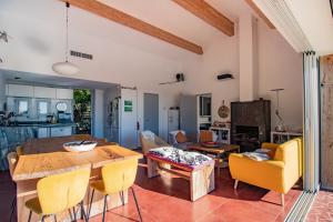eine Küche und ein Wohnzimmer mit einem Holztisch und Stühlen in der Unterkunft Maison Aux Vents in Monacia-dʼAullène