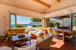 ein Wohnzimmer mit einem Tisch und einigen Stühlen in der Unterkunft Maison Aux Vents in Monacia-dʼAullène