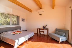 ein Schlafzimmer mit Bett, Stuhl und Schreibtisch in der Unterkunft Maison Aux Vents in Monacia-dʼAullène + 29 Fotos