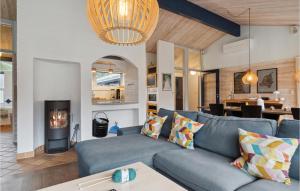 un soggiorno con un divano blu e un camino di Cozy Home In Ålbæk With Kitchen ad Ålbæk