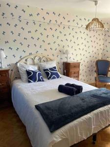 a bedroom with a large bed with blue pillows at Maison 8 pers, piscine, au cœur du pays de Cognac in Malaville