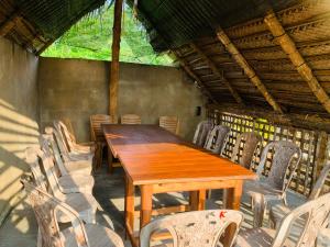 a wooden table and chairs in a room at The Heaven Sorabora in Mahiyangana