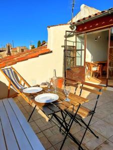 a wooden table and chairs on a patio at Appartement avec terrasse tropezienne, Aups in Aups