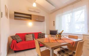 a living room with a red couch and a table at Holiday Home Barbariga 01 in Barbariga +10 photos