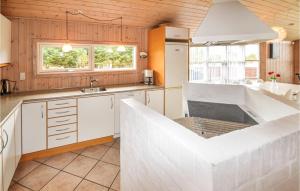 a kitchen with a large white island in the middle at Holiday Home Alexandravej Løkken Xi in Løkken +10 photos