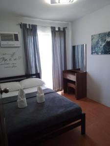 a bedroom with a bed and a desk and a window at Cagayan de oro One Oasis - 2 Bedroom Unit in Cagayan de Oro
