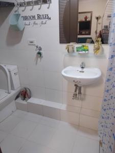 a white bathroom with a sink and a bath tub at Cagayan de oro One Oasis - 2 Bedroom Unit in Cagayan de Oro
