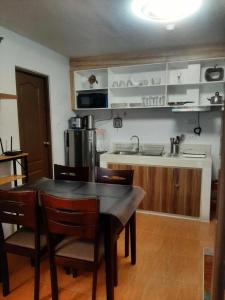a kitchen with a table and chairs and a kitchen with a sink at Cagayan de oro One Oasis - 2 Bedroom Unit in Cagayan de Oro