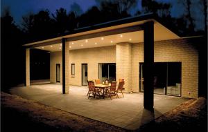 a patio with a table and chairs on it at night at Four-Bedroom Holiday Home In Ebeltoft in Ebeltoft