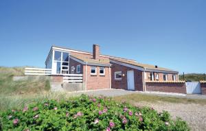 a brick house on a hill with pink flowers at Four-Bedroom Holiday Home In Hvide Sande in Bjerregård