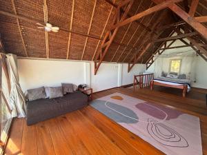 a living room with a couch and a bed at Valhalla Mentawai in Katiet