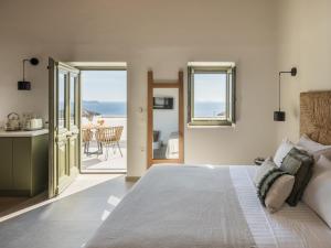 a bedroom with a bed and a view of the ocean at Saluti Da Stampalia Chora in Pera Gyalos