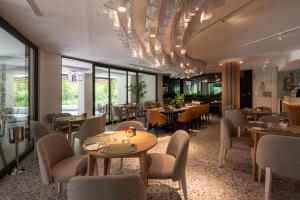 a restaurant with tables and chairs and windows at Steyn City Hotel by Saxon in Midrand