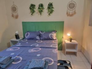 a bedroom with a large bed with a green headboard at Casa Cisalta N5 - Quarto Casal in Praia