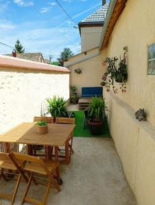 a patio with a wooden table and chairs in a house at Gîte Cosy Jacuzzi privatif proche Paris et Giverny in La Boissière