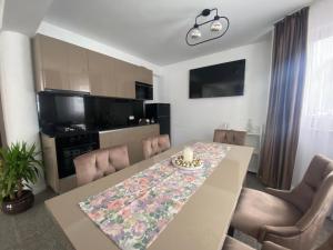 a kitchen and dining room with a table and chairs at Apartament HATERE in Moisei +13 photos