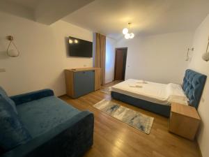a living room with a bed and a couch at Apartament HATERE in Moisei
