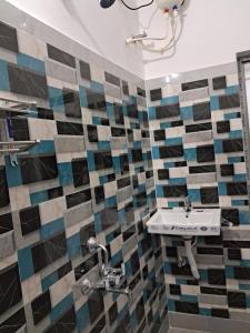 a bathroom with a sink and mosaic tiles on the wall at Diya Homestay in Rāmpur Hāt +32 photos