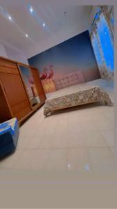 チュニスにあるDar Elineの壁に絵が飾られたベッドのある寝室