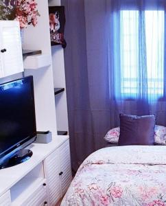 a bedroom with a bed and a tv and a window at Habitacion privada Valencia in Valencia