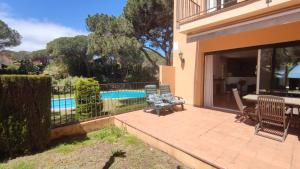 a patio with a table and chairs next to a pool at VILLAS COSETTE Villa Cami de les Penyes in GRO
