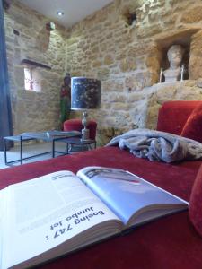 a book sitting on top of a bed at Domaine de Cantegrel - Gîtes de Charme et Suite Troglodyte en Périgord in Vitrac