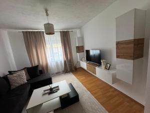 a living room with a black couch and a tv at Ferienwohnung mitten in Fulda in Fulda