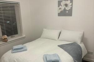 a bedroom with a bed with two towels on it at 2-Beds Sleeps 4 w Parking 15 mins to St Andrews in Anstruther