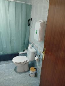 une salle de bain avec toilettes et un rideau de douche vert dans l'établissement Vivienda cercana a la playa con todas las comodidades, à Tarifa