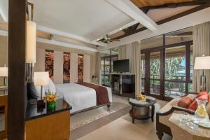 1 dormitorio con 1 cama y sala de estar en Henann Resort Alona Beach en Panglao City