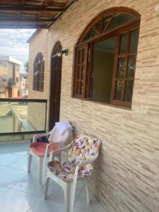 two chairs and a window on a balcony at Refugio da Marvila in Marataizes