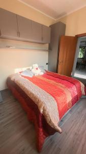 a bedroom with a bed with a red and white blanket at Casa del Cerbiatto, Lake Como a 5 chilometri da Argegno in Castiglione dʼIntelvi